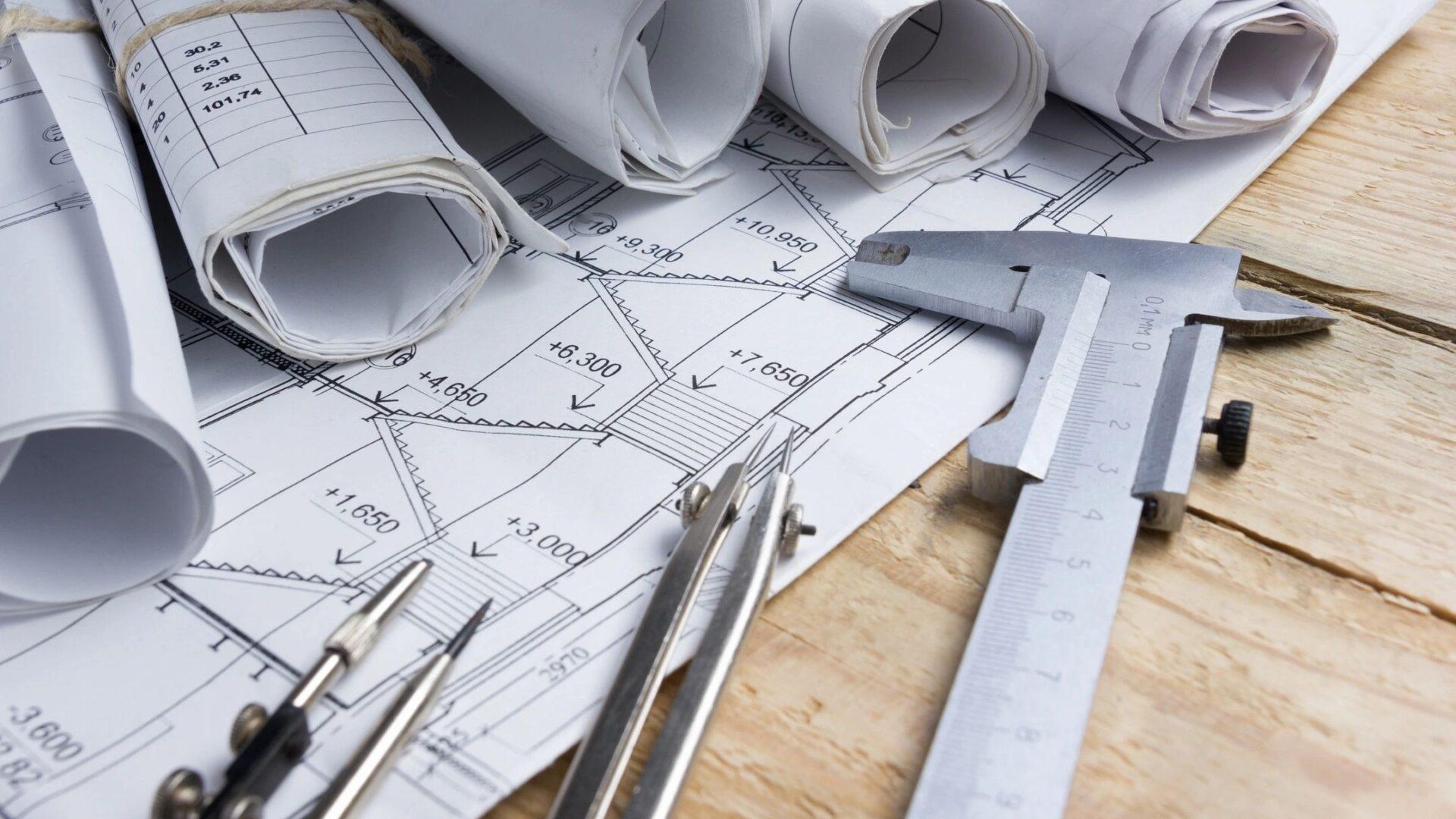 Technical drawing tools and blueprints on a workspace.