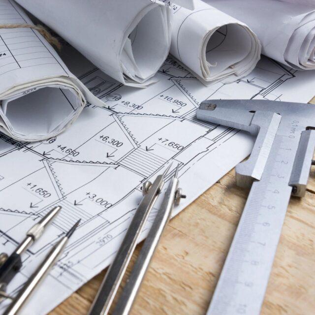 Technical drawing tools and blueprints on a workspace.